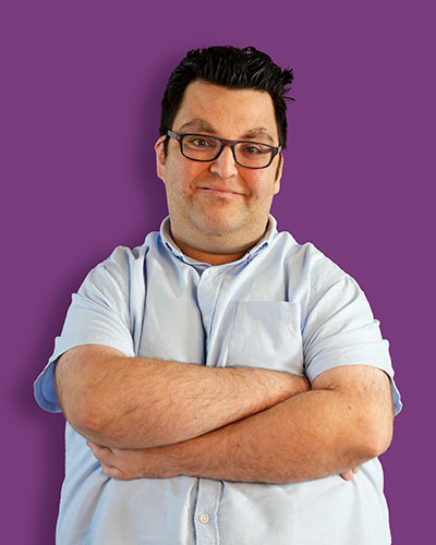 A portrait of our artist James against a purple background - Mawaheb Art Studio for People of Determination