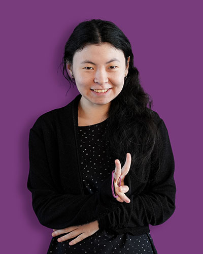 A portrait of our artist Angelina against a purple background - Mawaheb Art Studio for People of Determination