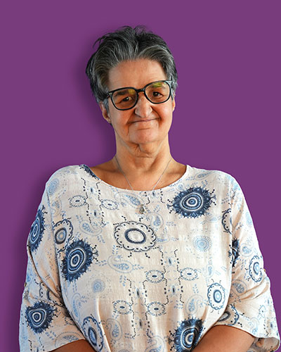 A portrait of our artist Leila against a purple background - Mawaheb Art Studio for People of Determination