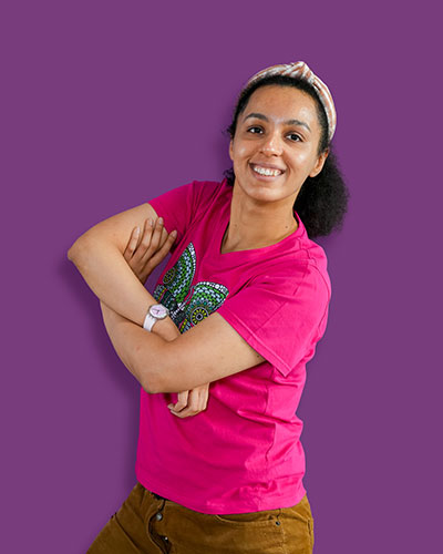 A portrait of our artist Namrata against a purple background - Mawaheb Art Studio for People of Determination