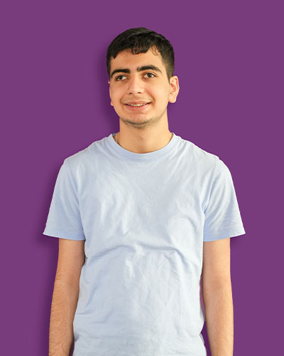 A portrait of our artist Marwan against a purple background - Mawaheb Art Studio for People of Determination